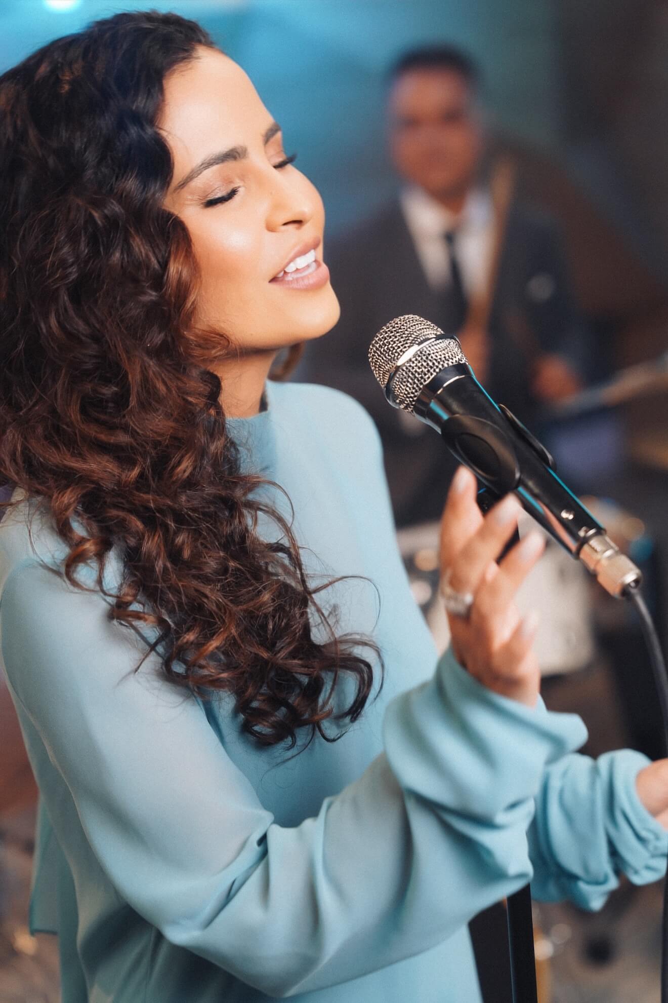 A Renata cantando ao microfone